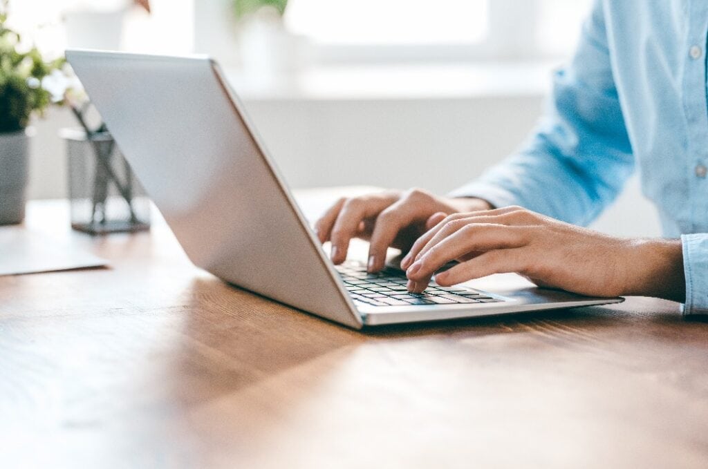 Hands of young contemporary office manager over laptop keypad during work